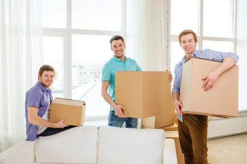 Professional movers loading furniture into a Roehampton moving truck
